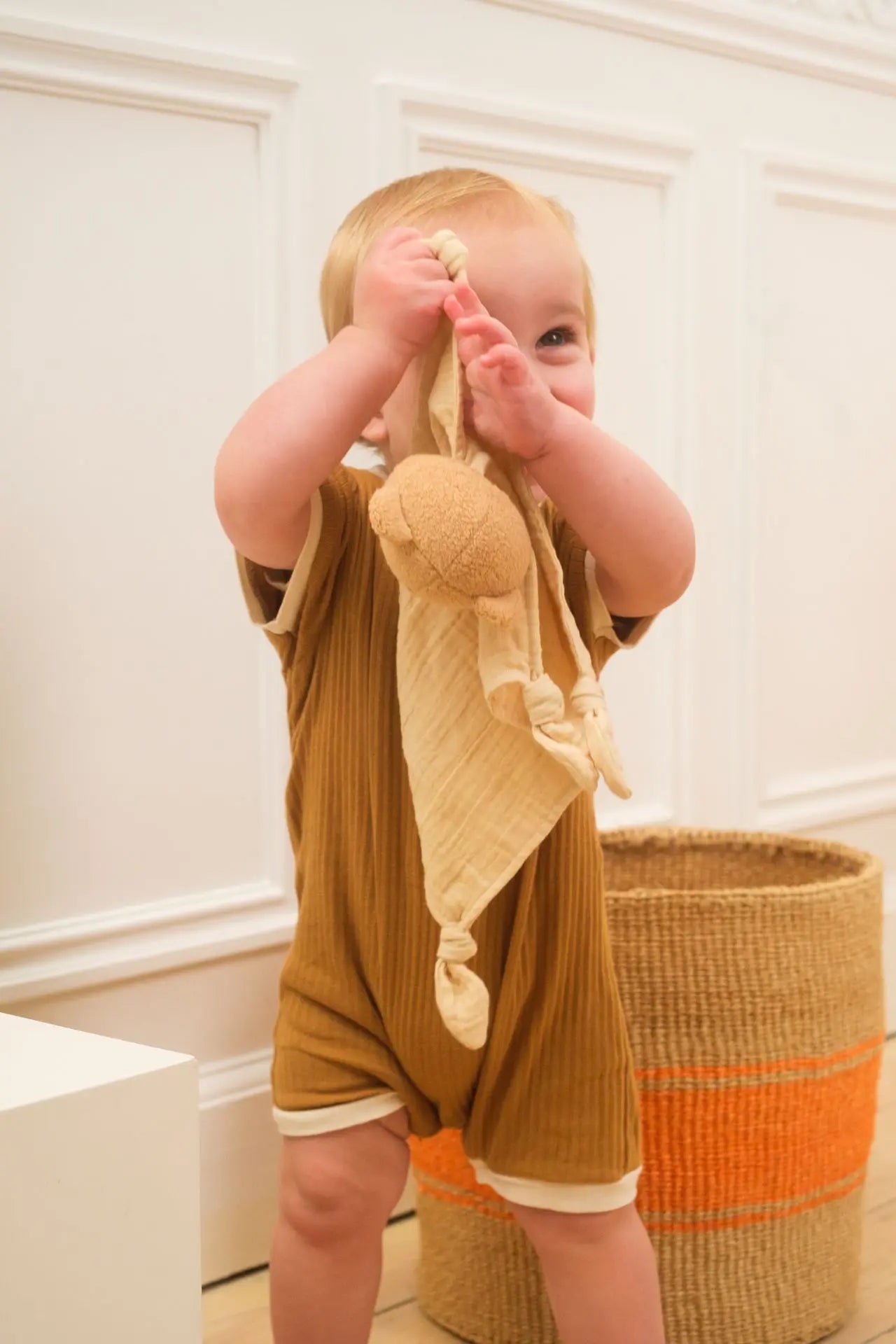 Bebé sosteniendo el doudou Oso Marcel